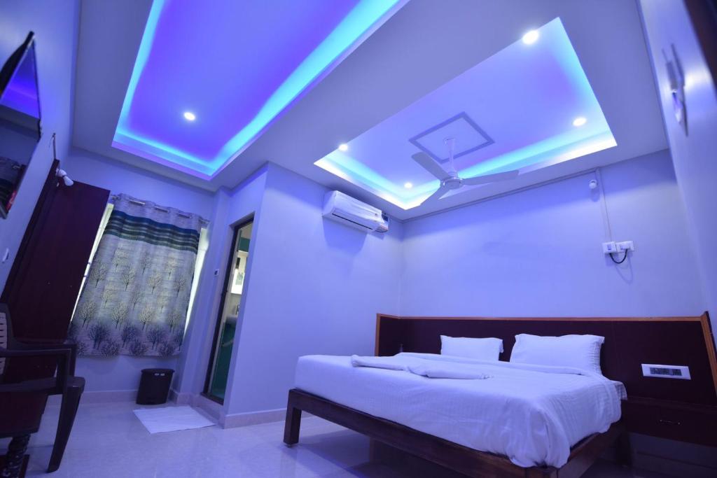 a bedroom with a large bed with a blue ceiling at AP Residency in Toludūr