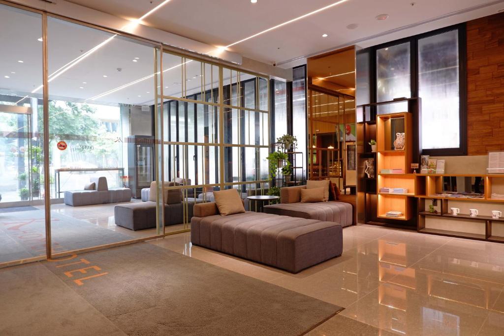 a living room with a couch and chairs and windows at Home Hotel in Taipei