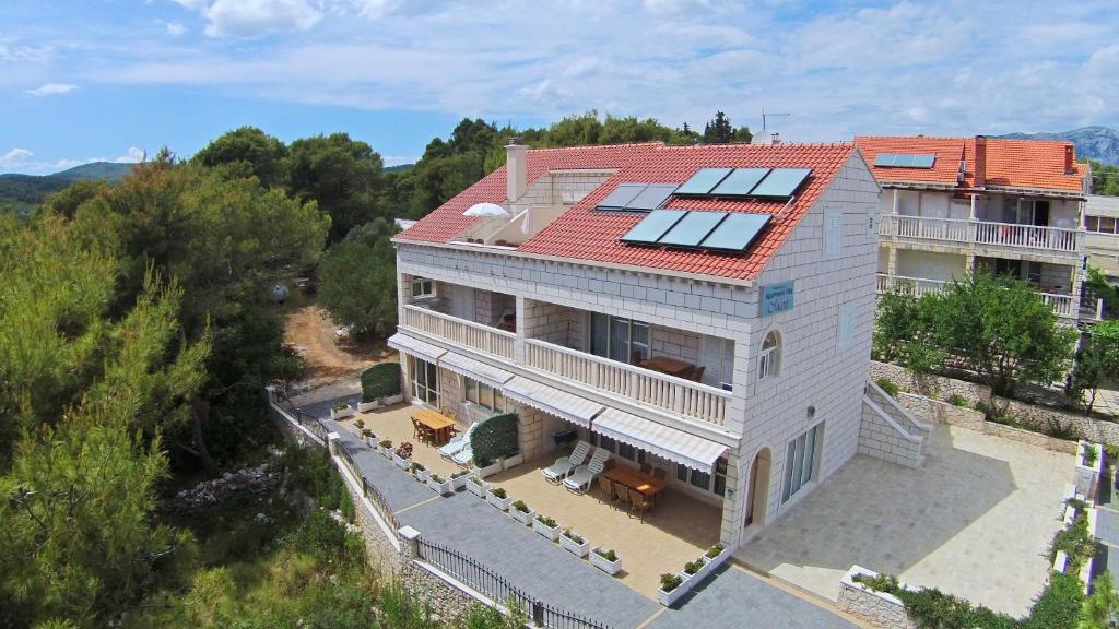 an aerial view of a house with solar panels on the roof at Apartments Villa Maris in Lumbarda