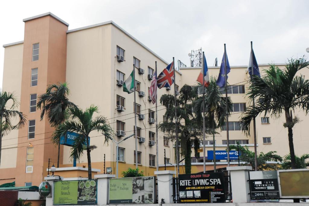 un gran edificio con banderas delante en Golden Tulip Hotel Port Harcourt -GTPH, en Port Harcourt