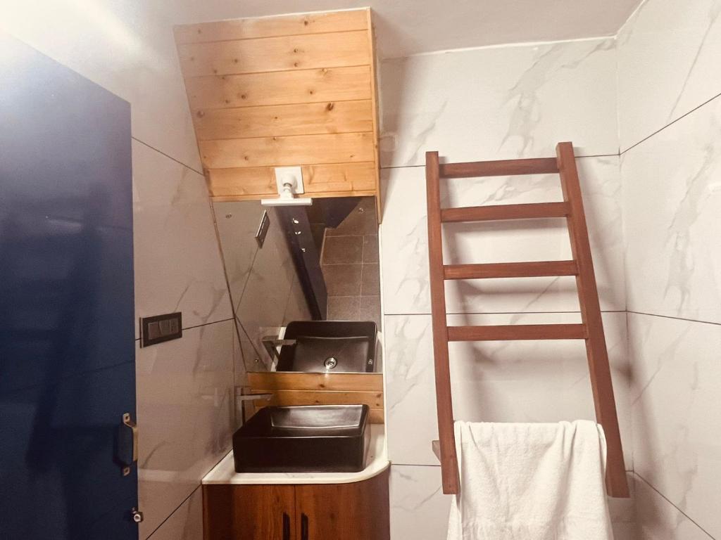 Baño pequeño con aseo y escalera en Tierra Villas Campsite -Udupi, en Padubidri