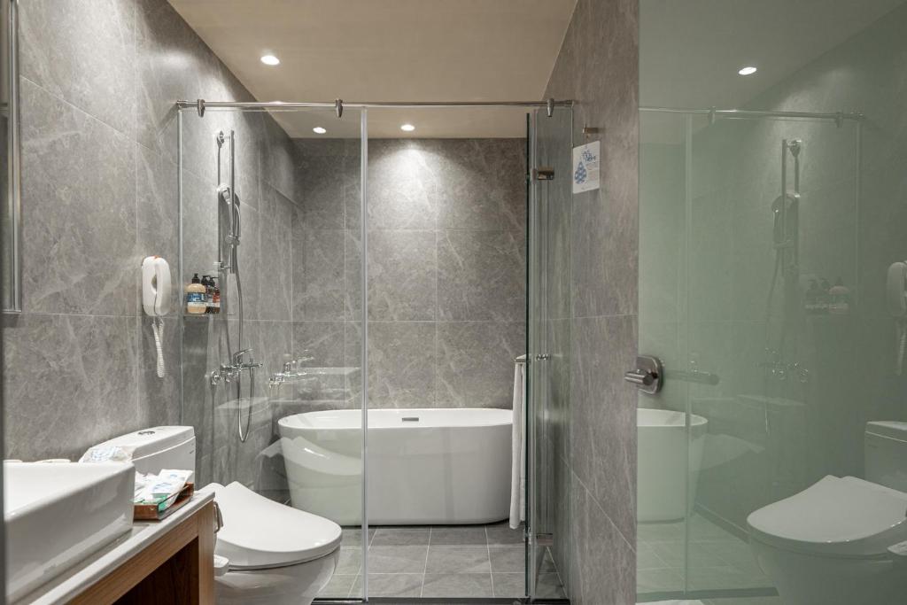 a bathroom with a shower and a toilet and a sink at Home Hotel in Taipei