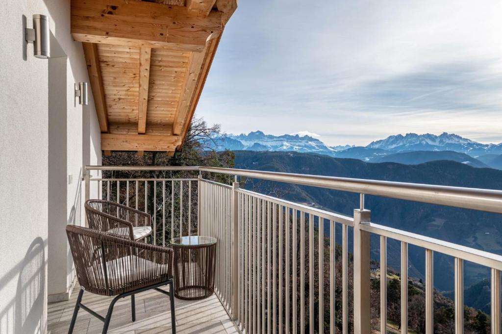 a chair on a balcony with a view of mountains at Reiterhof Apt Gaia in San Genesio Atesino