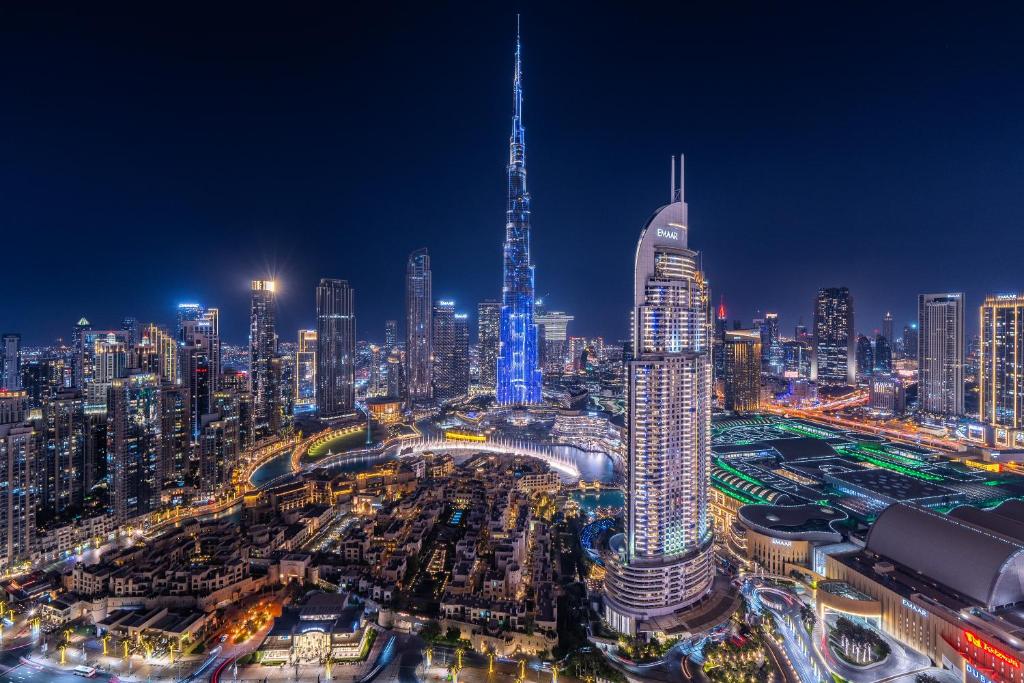 a city skyline at night with a tall tower at Lavishly Elegant 2BR with Breathtaking Full Burj Khalifa View in Dubai