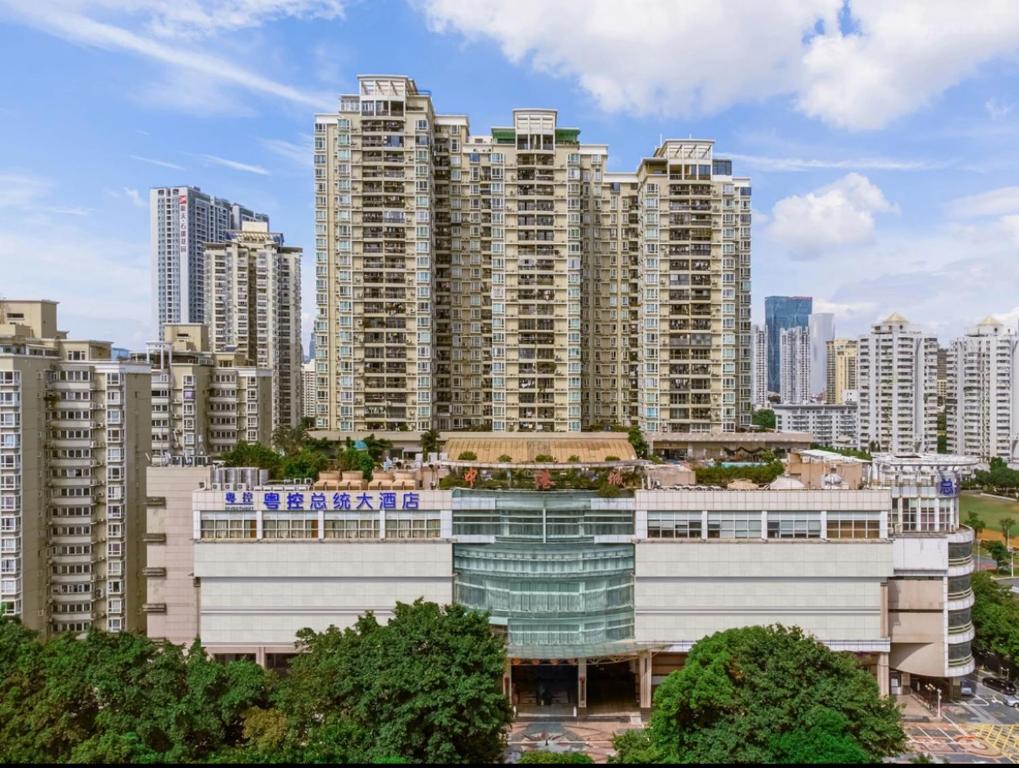 ein Gebäude vor einer Stadt mit hohen Gebäuden in der Unterkunft President Hotel Shenzhen - Yitian Metro Station in Shenzhen