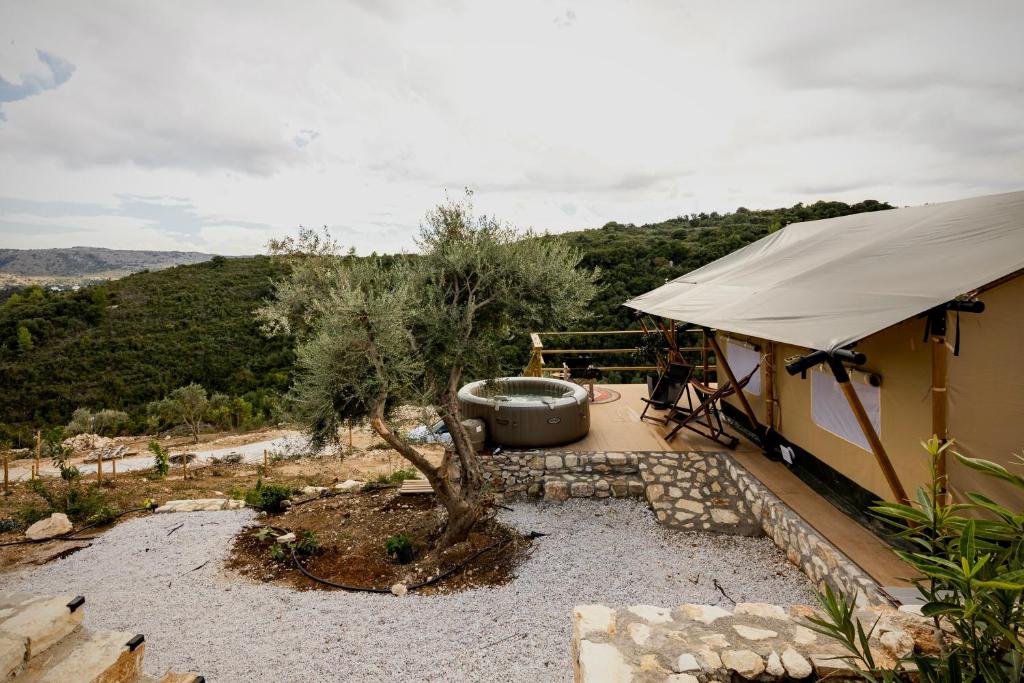 a house with a tub sitting next to at Civara Chalet - Glamping in Tsivarás