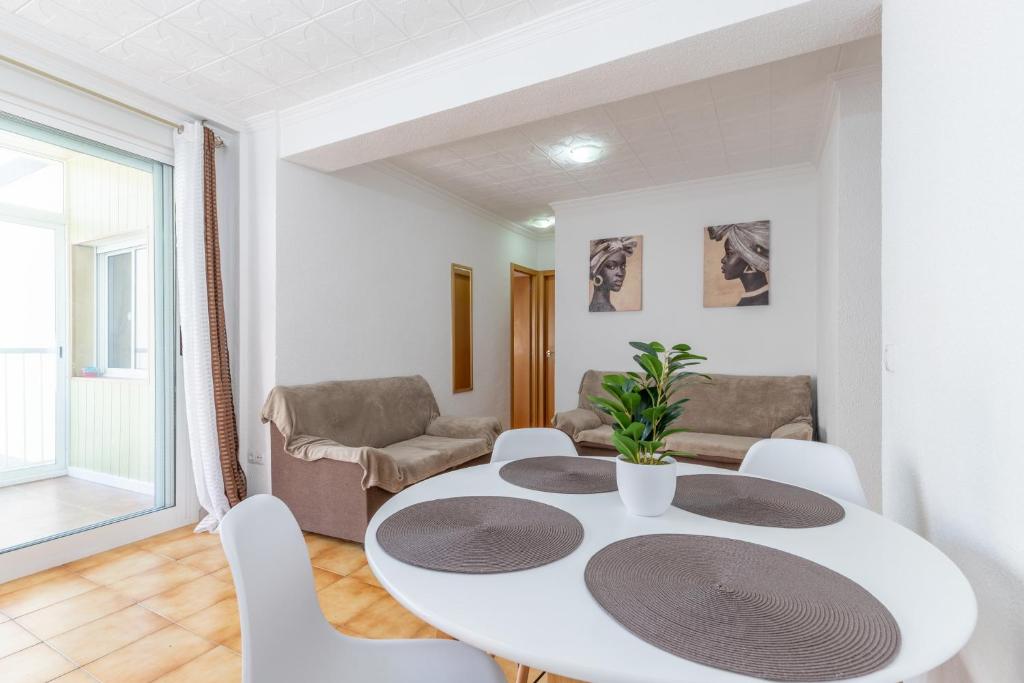 ein weißes Esszimmer mit einem weißen Tisch und Stühlen in der Unterkunft Larisa Apartment in Benidorm