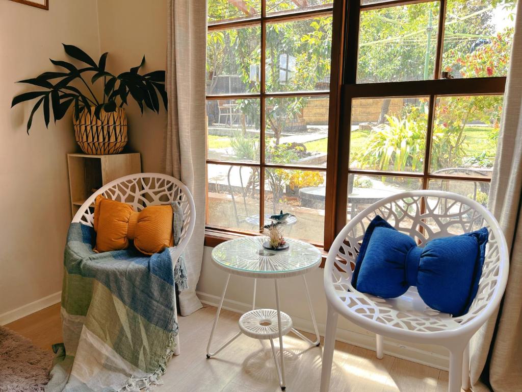 two chairs and a table in a room with a window at 阳光花园小屋，近沙滩 in Kingston Beach