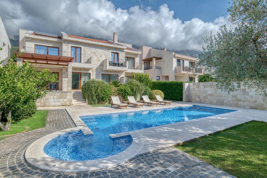 a villa with a swimming pool in front of a house at Villa Zen Port in Petrovac na Moru