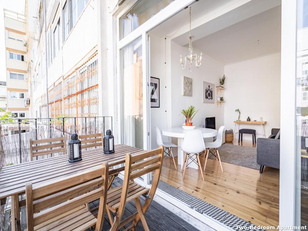 um apartamento com uma varanda com uma mesa e cadeiras em Akicity Ourique Selected em Lisboa