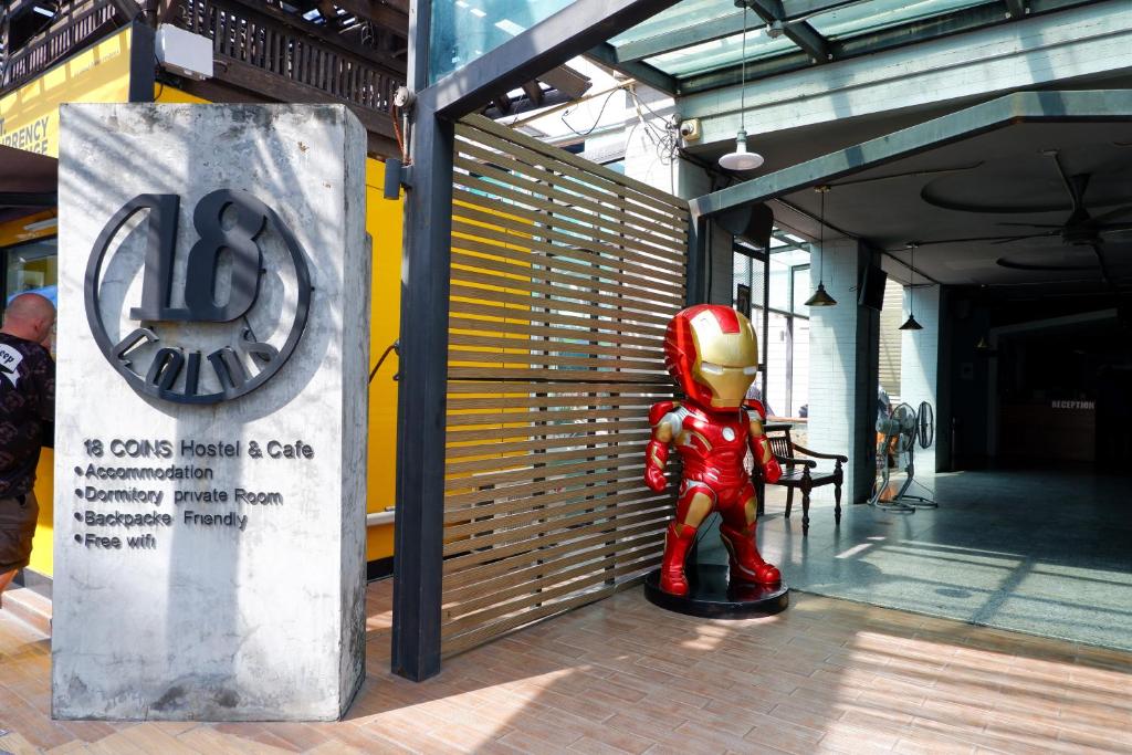 a superhero statue sitting in front of a building at 18 Coins Budget Hotel in Pattaya Central