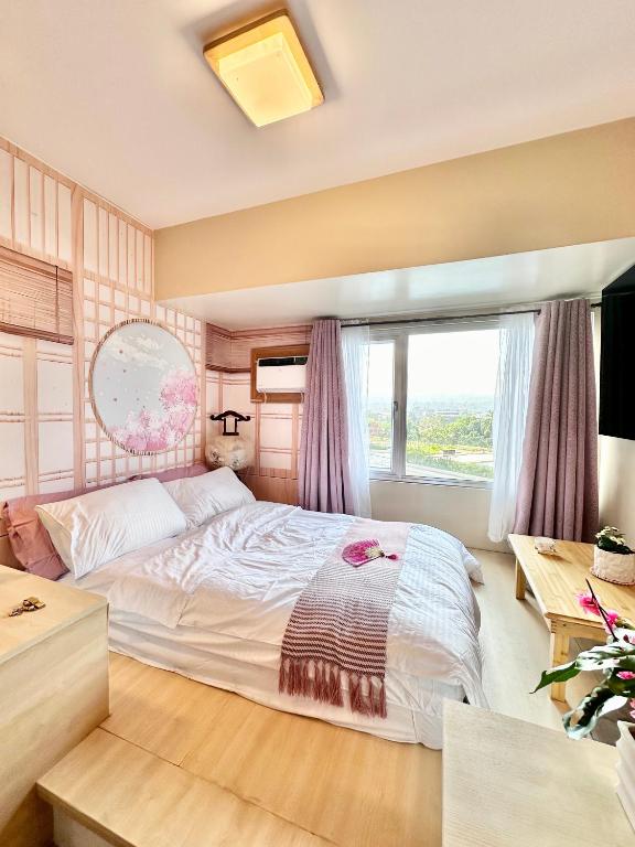 ein Schlafzimmer mit einem großen Bett und einem Fenster in der Unterkunft Doms Ryokan in Avida Aspira With Wifi and Netflix in Cagayan de Oro