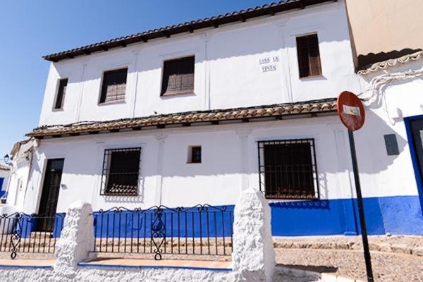 una casa blanca con una valla azul delante de ella en Casa La Venta, en Campo de Criptana