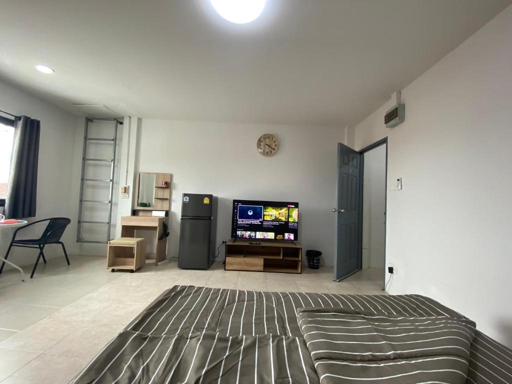 a living room with a bed and a flat screen tv at 84 Bar & Guest House Room 5 in Ban Huai Luk (1)