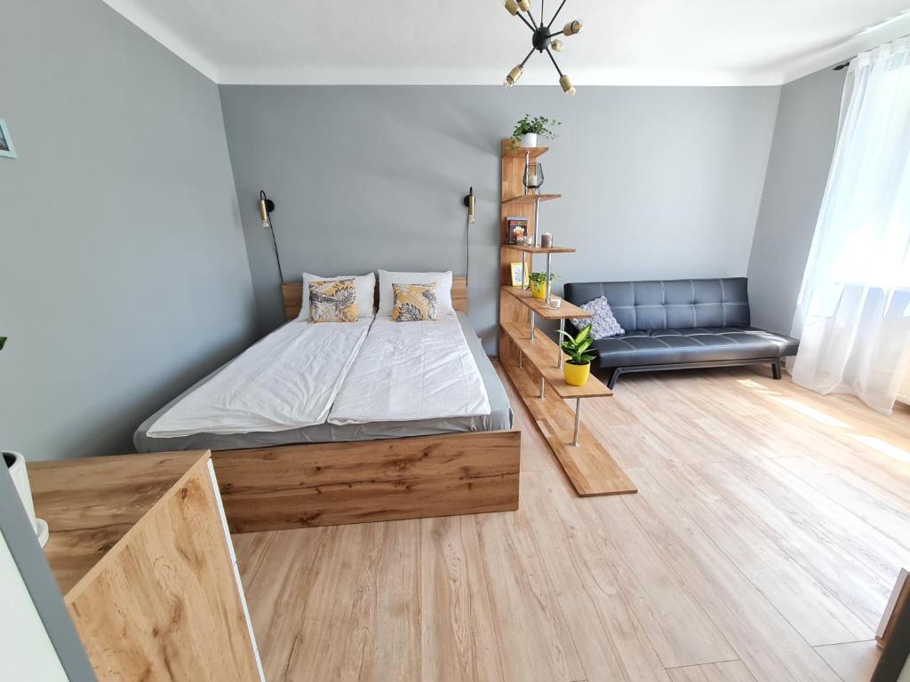 a bedroom with a bed and a couch at The sunny willow apartments in Liepāja