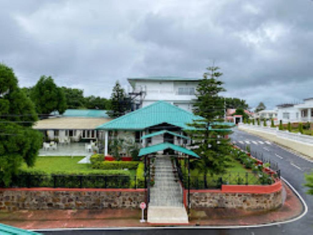 a house on the side of a road with a building at dup in Shillong