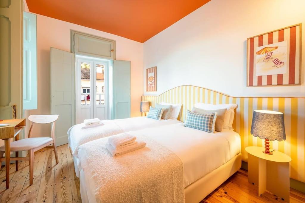 a bedroom with two beds and a table at GuestReady - Casas Do Tanoeiro in Porto Brandão