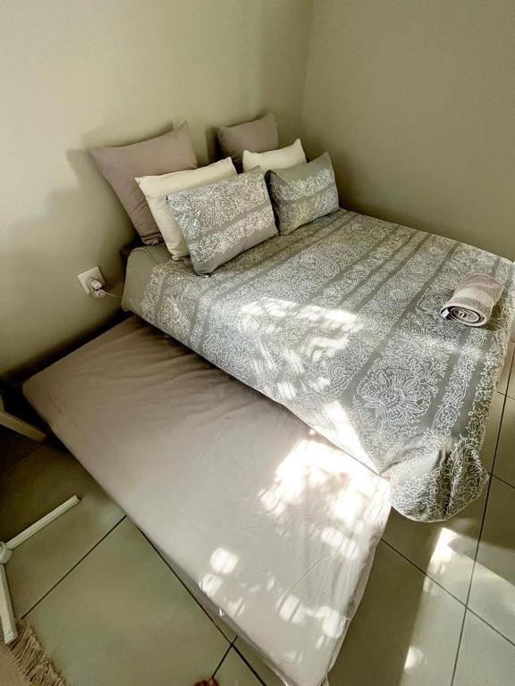a large bed in a small room with at Wamelia Guesthouse in Bloemfontein