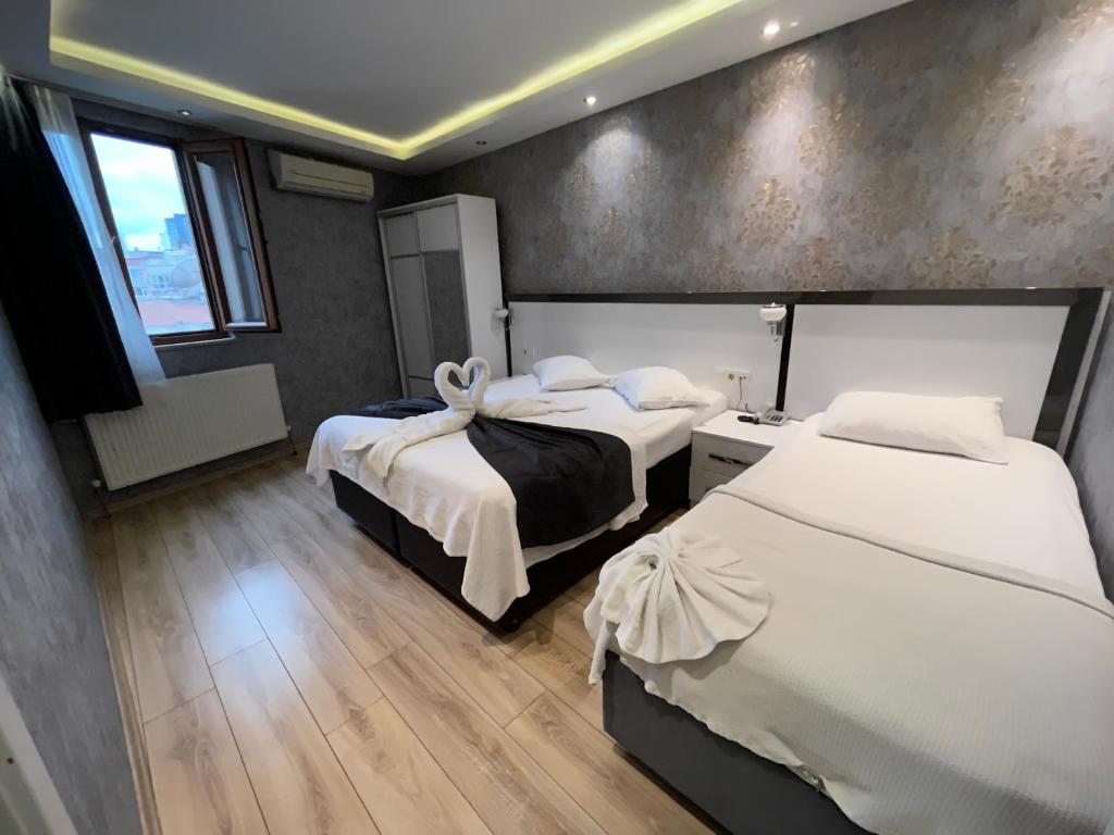una camera d'albergo con due letti e una finestra di ŞİŞLİ LÜX DAİRE AND HOME a Istanbul