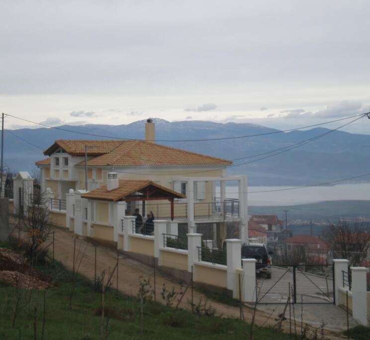 uma grande casa branca com um alpendre numa colina em VILLA EFTYXIA - Mendenitsa em Mendhenítsa