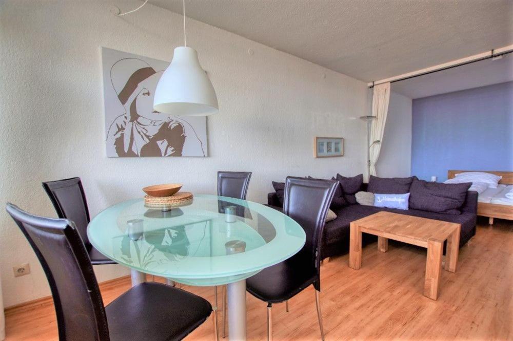 - un salon avec une table en verre et un canapé dans l'établissement Ferienpark - Haus L, App 0L0802, à Heiligenhafen