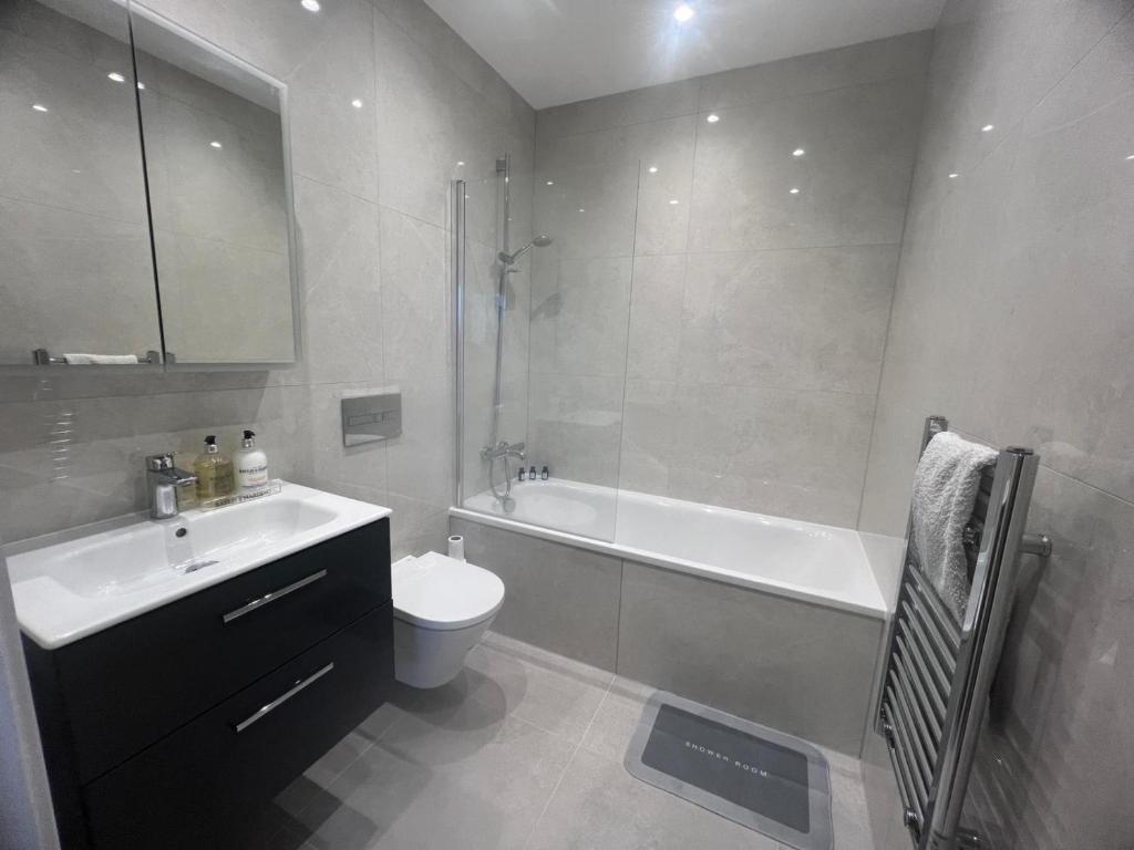La salle de bains est pourvue d'une baignoire, de toilettes et d'un lavabo. dans l'établissement New build 1 bedroom modern apartment Rickmansworth, à Rickmansworth