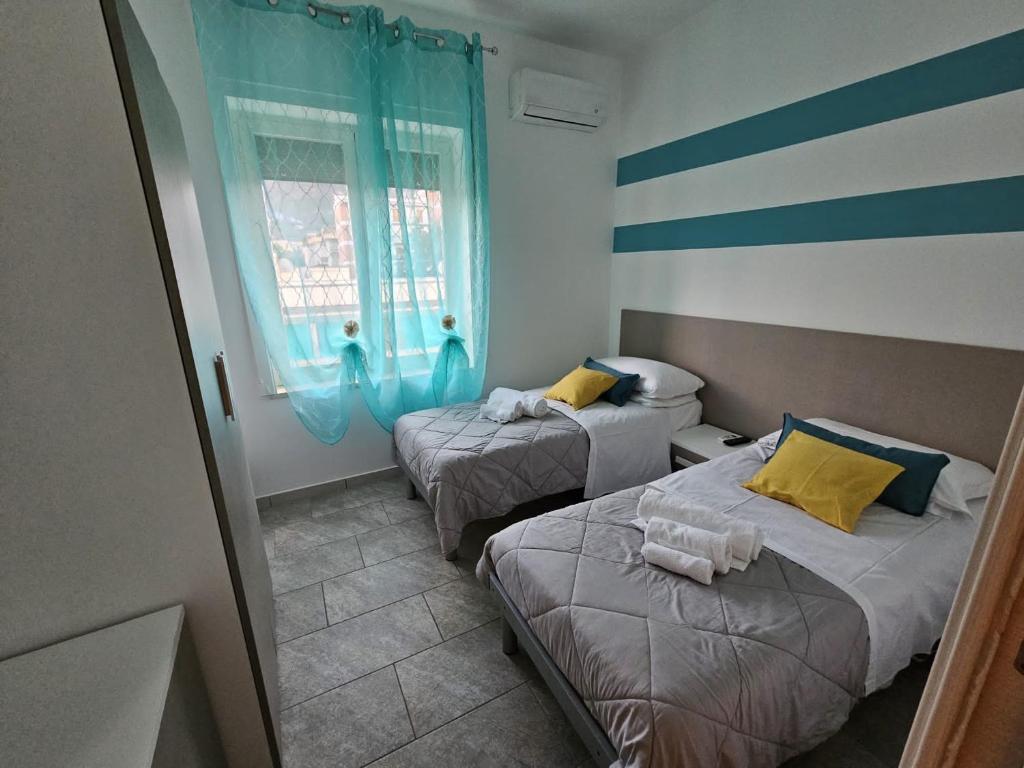 2 Betten in einem kleinen Zimmer mit Fenster in der Unterkunft sorrento sleepandgo in Sorrent