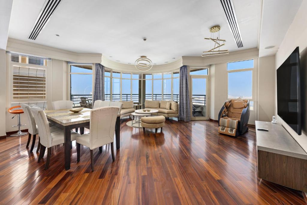 a dining room with a table and chairs and a living room at Superhost Sea View Spacious 202 square meters apartment luxury property in Dubai
