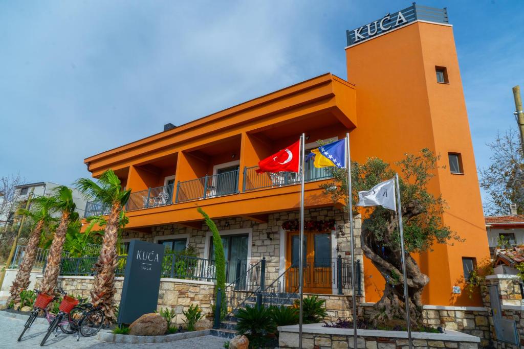 un edificio naranja con banderas delante en KUCA URLA en Urla