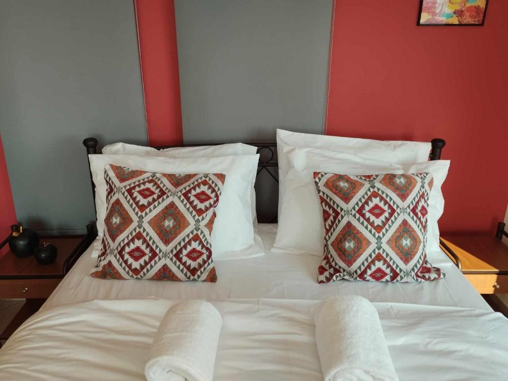 un letto con lenzuola e cuscini bianchi in una camera da letto di Nest & nook a Chio (Chios)