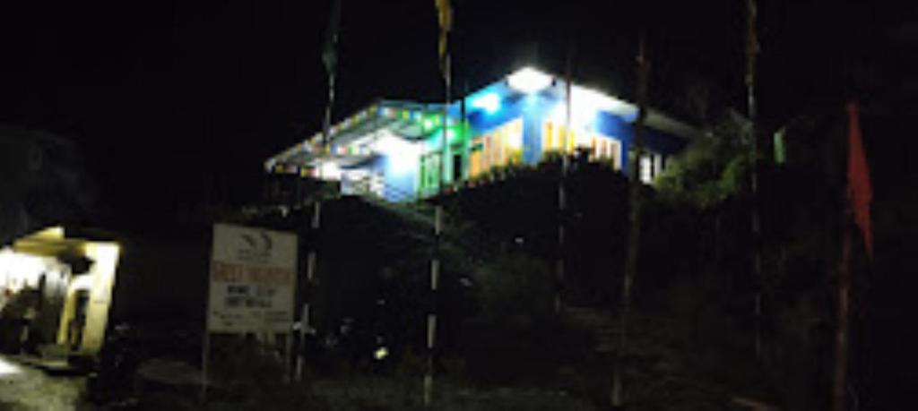 um edifício com luzes azuis à noite em Green Mountain Homestay Munshyari em Munsyari