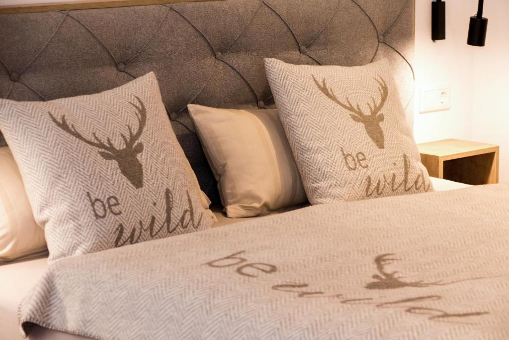 a bed with two pillows with deer heads on it at Appartement Rehlein in Mauterndorf