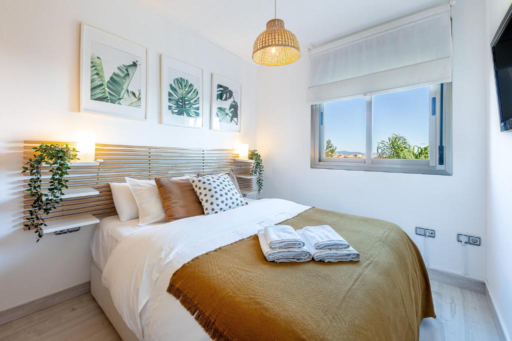 1 dormitorio con 1 cama con 2 toallas en Vivendos - Moderno Apartamento con Piscina, en Torremolinos