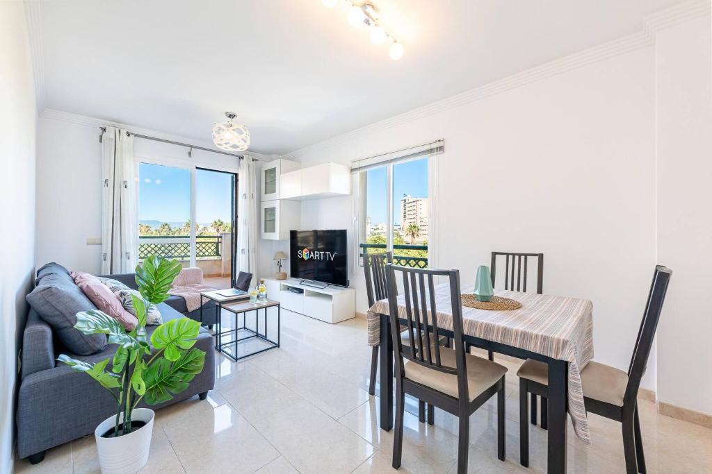 a living room with a couch and a dining room table at Estupendo apartamento junto a magníficas playas in Torremolinos