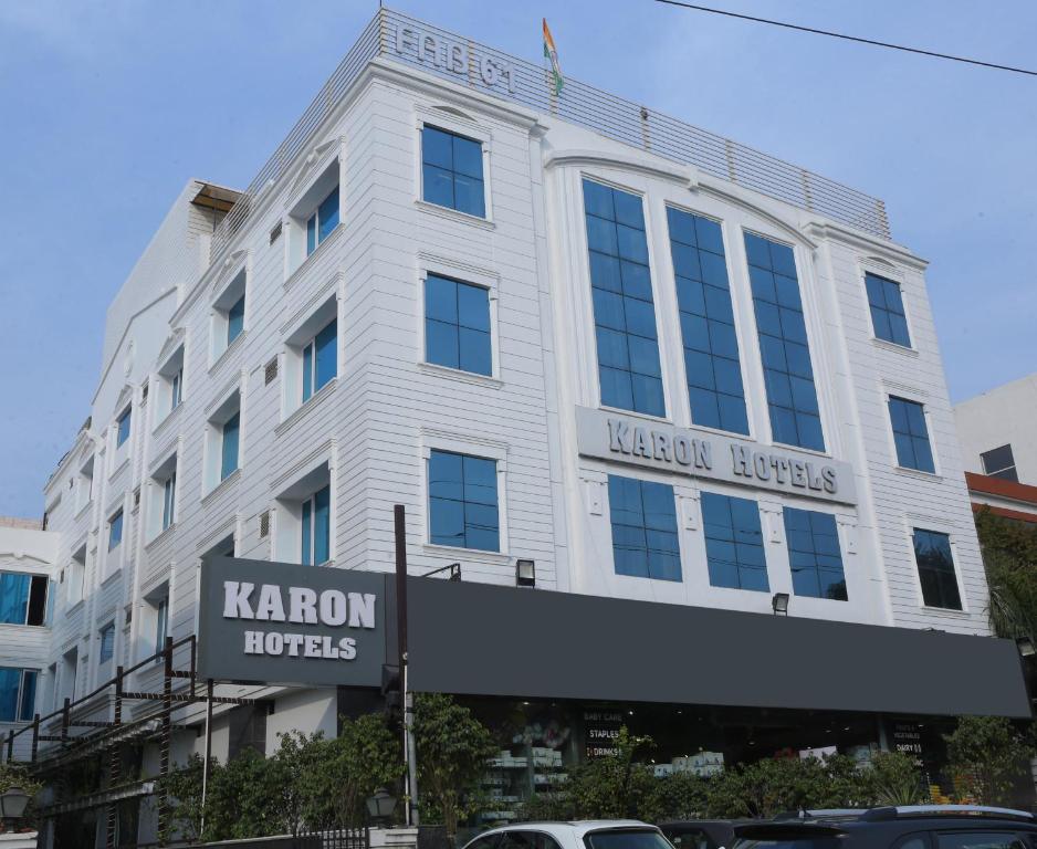 ein weißes Gebäude mit einem Schild davor in der Unterkunft Karon Hotels - Lajpat Nagar in Neu-Delhi