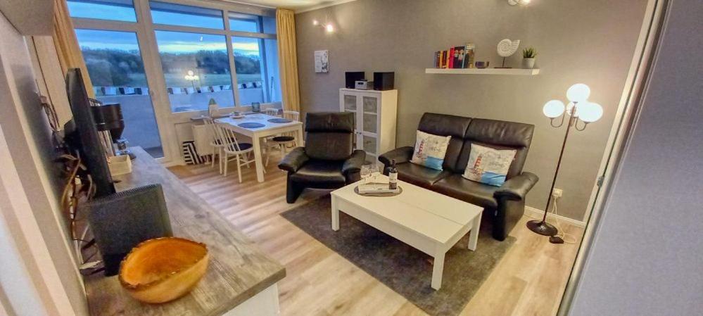 ein Wohnzimmer mit einem Sofa und einem Tisch in der Unterkunft Ferienpark - Haus N, App 0N0502 in Heiligenhafen