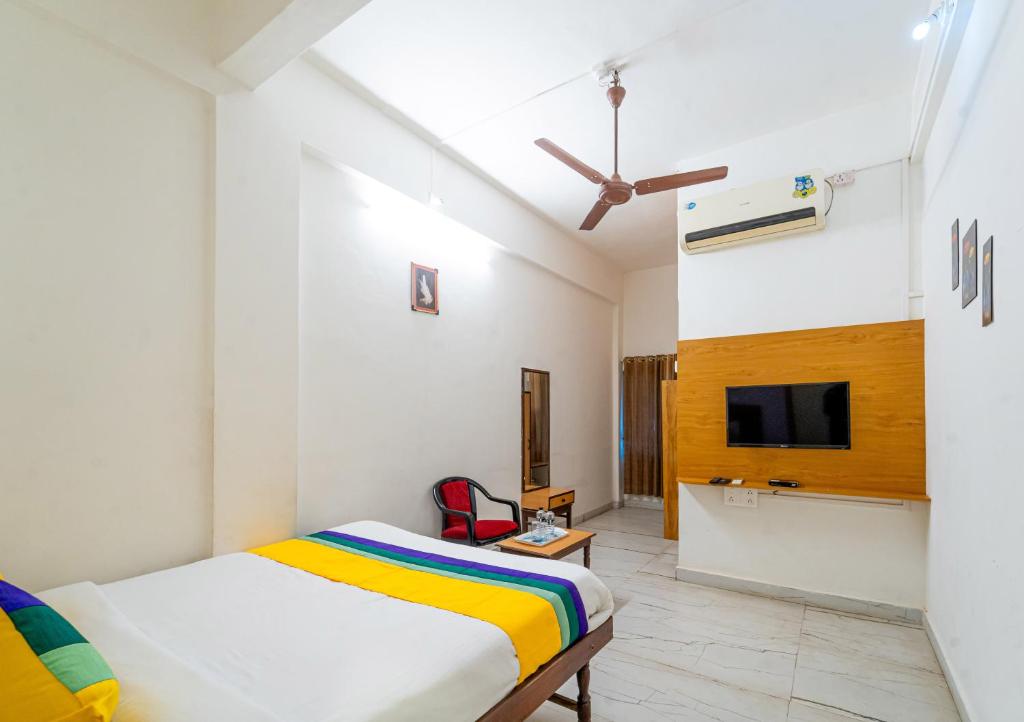 a bedroom with a bed and a tv on a wall at Itsy By Treebo - Mansi in Nashik