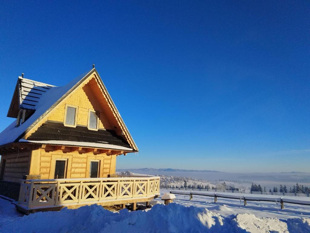 a log cabin with snow on the ground at Zymbiańsko Chałupa 2 z jacuzzi in Ząb