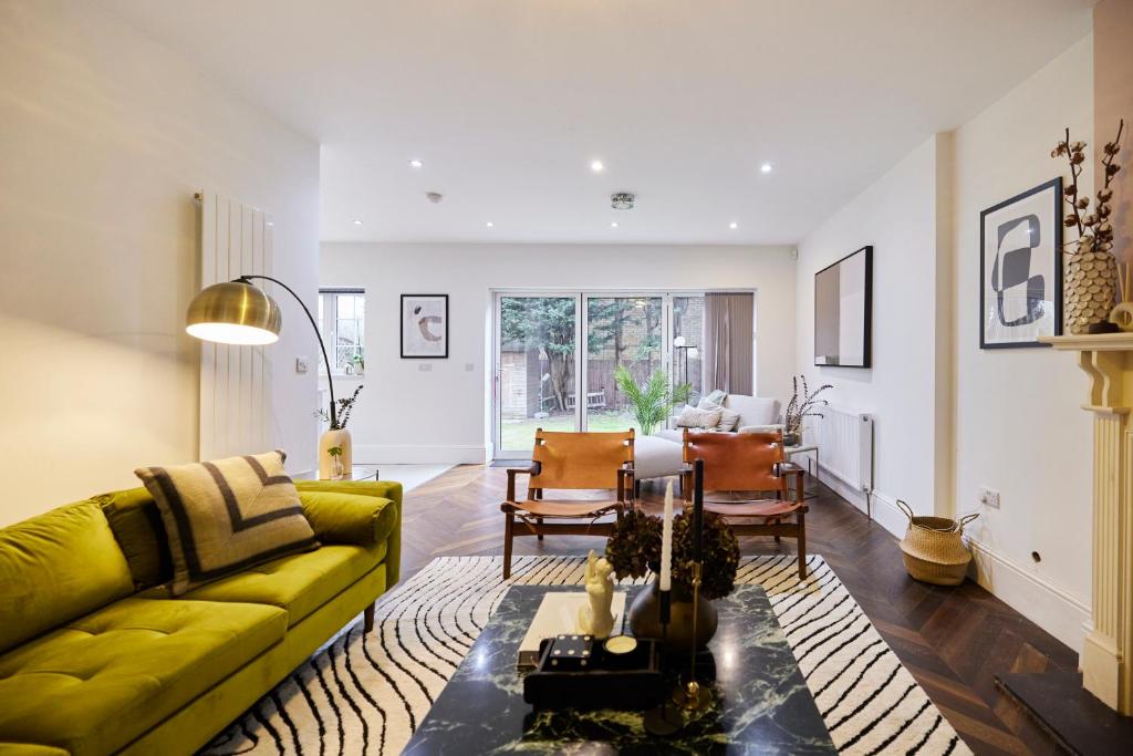 een woonkamer met een gele bank en een tafel bij The Redbridge Sanctuary - Spacious 3BDR House with Garden in Londen