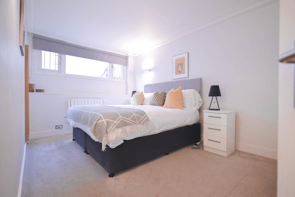 een slaapkamer met een groot bed en een raam bij Camden Serviced Apartments by Globe Apartments in Londen