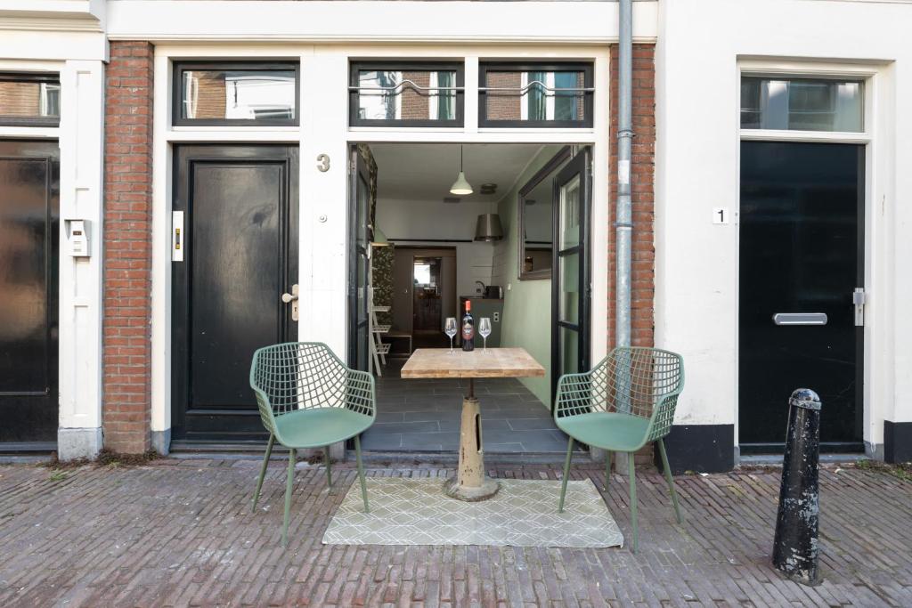 a patio with two chairs and a table in front of a building at Beautiful apartment in vibrant Utrecht City Center in Utrecht