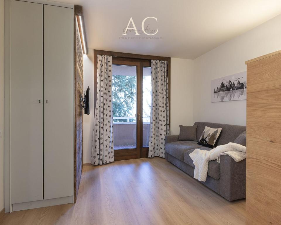ein Wohnzimmer mit einem Sofa und einem Fenster in der Unterkunft Appartamento Mirella Wood in Ponte di Legno