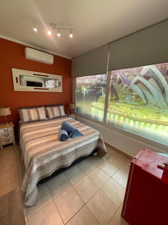 a bedroom with a bed and a large window at Apartamento/Estudio en Las Condes in Santiago