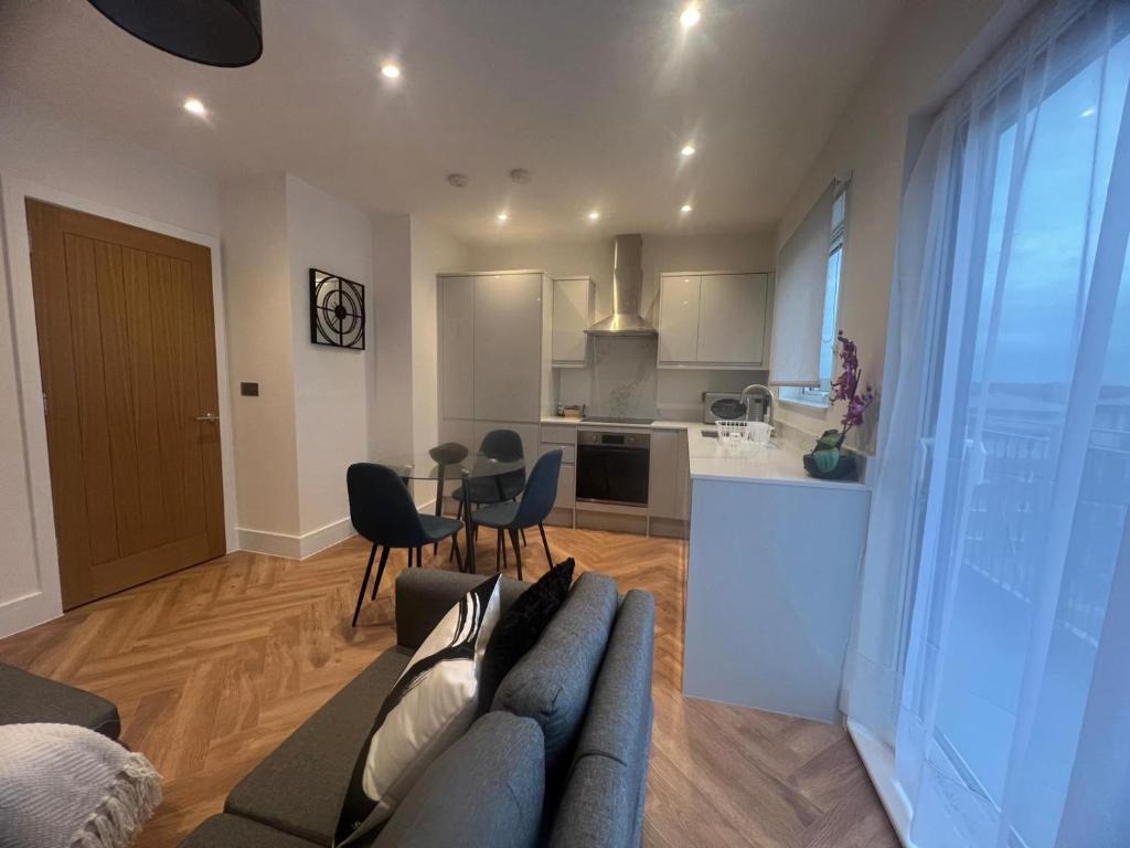 a living room with a couch and a kitchen at New 2 Bedroom Apartment Rickmansworth Town Centre in Rickmansworth
