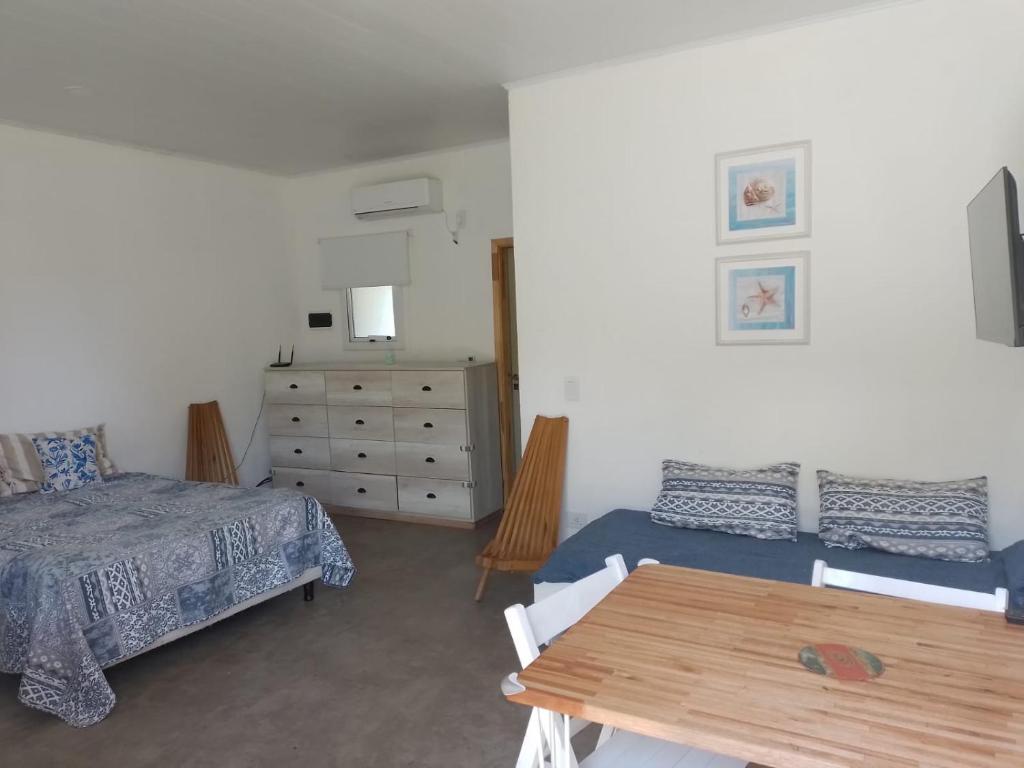 een slaapkamer met een bed, een tafel en een dressoir bij OstendeZen in Ostende