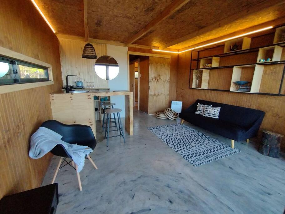 een woonkamer met een bank en een tafel bij Cabaña la Vega matanzas vista al mar in Polcura