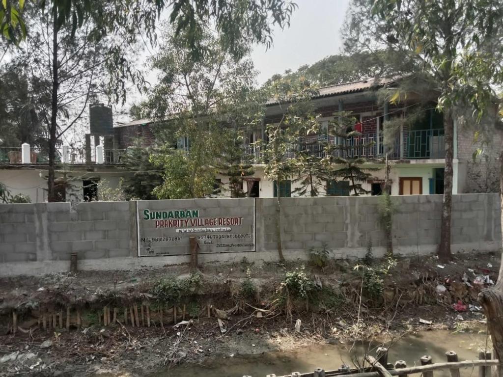 un edificio con una señal delante de él en Prakrity Village Resort Sundarbans, en Gosāba