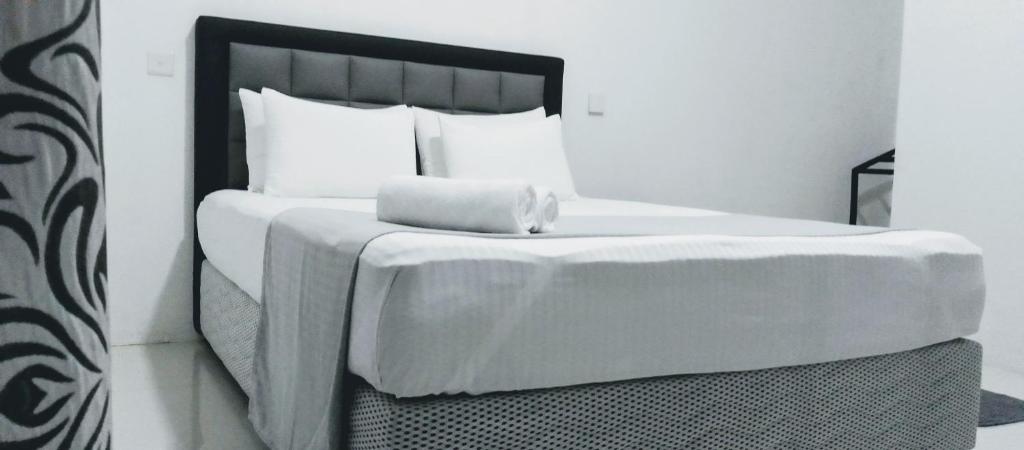 - un lit avec une couverture blanche et des oreillers dans l'établissement The Inn At Matale, à Matale