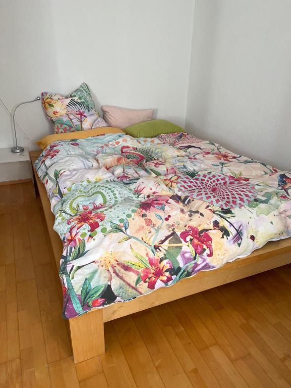 - un lit avec une couette à fleurs dans une chambre dans l'établissement Privat Bed and Breakfast in Flims Waldhaus, à Flims