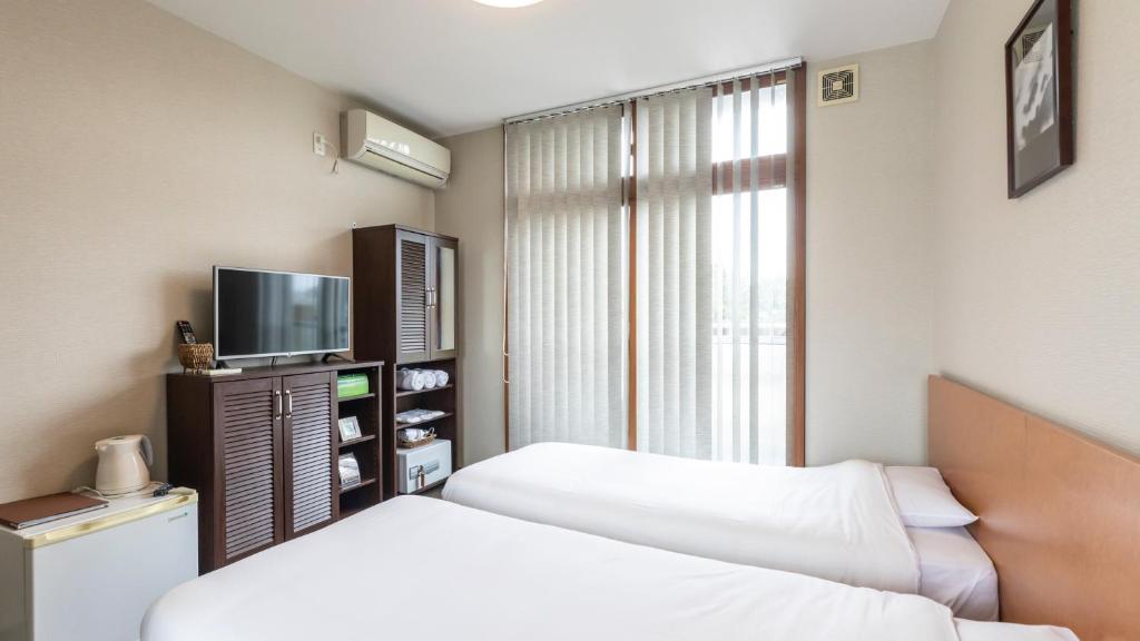 Postel nebo postele na pokoji v ubytování Tabist International Hotel Kaike
